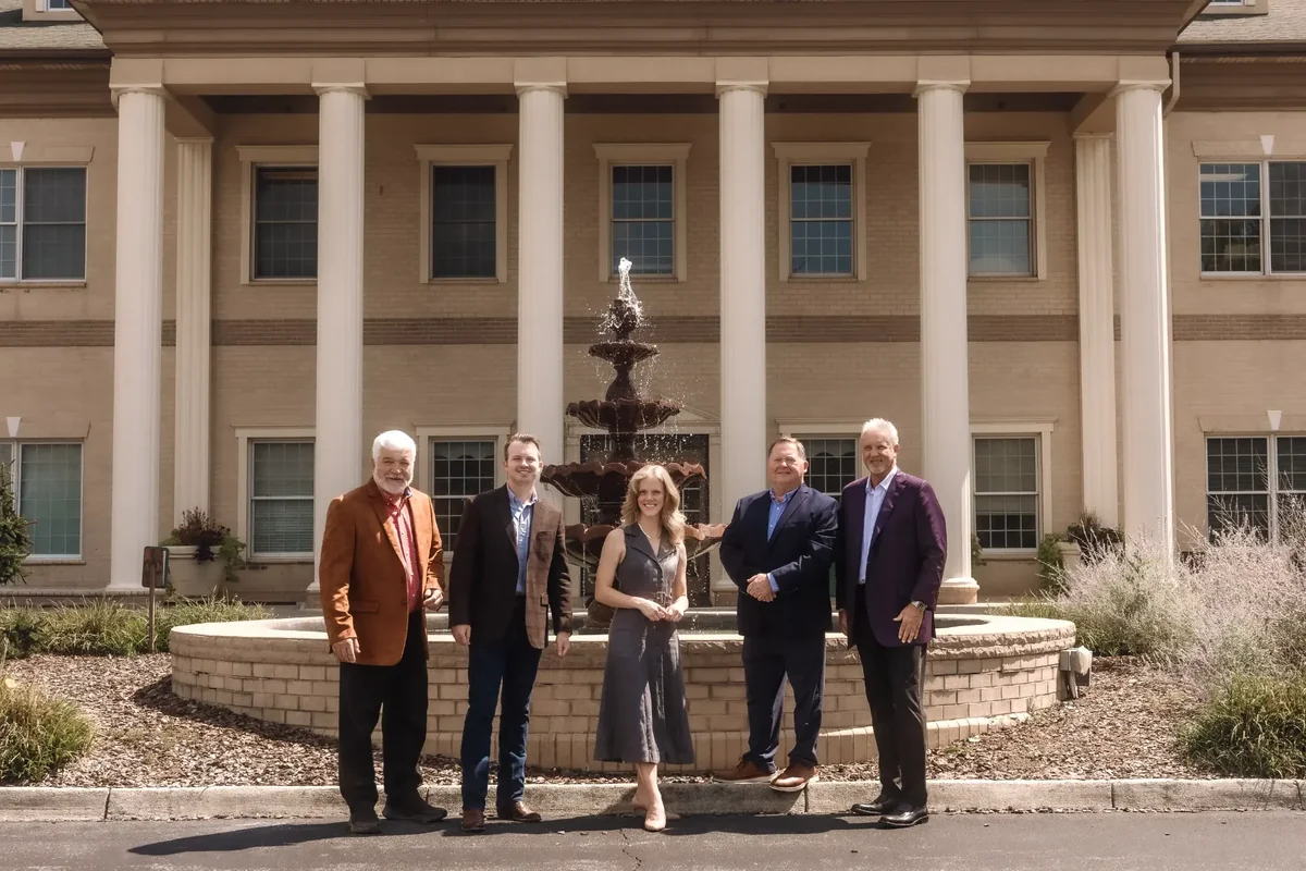 Price Richards team standing in front of a fountain outside a columned building